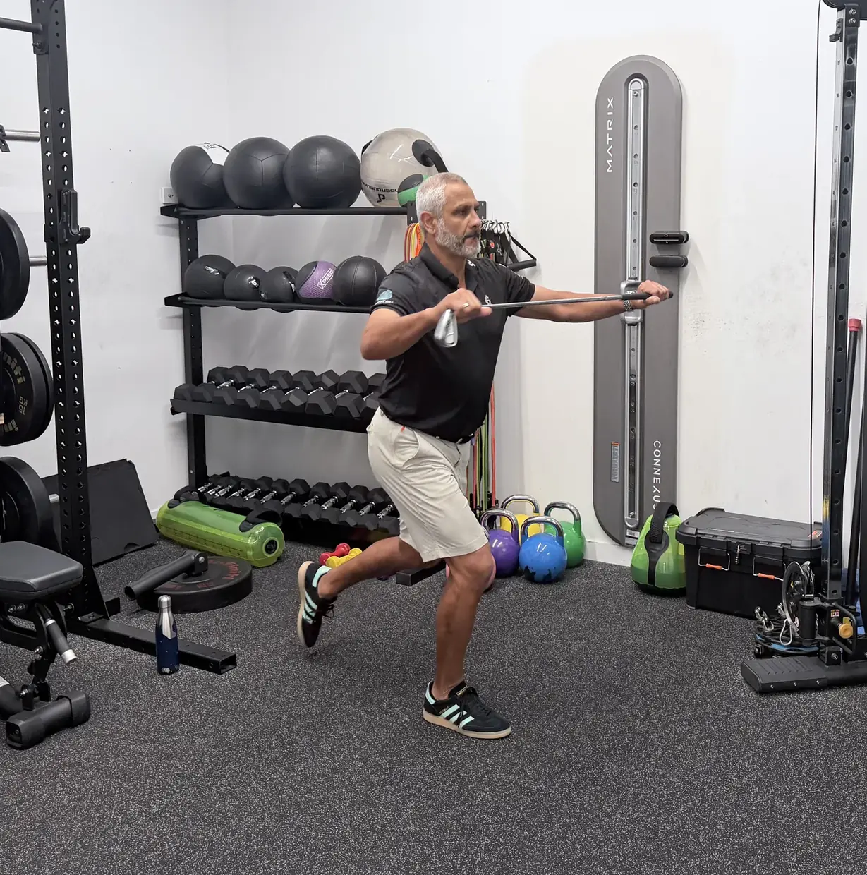 A reverse lunge with a golf club held out in front at chest height